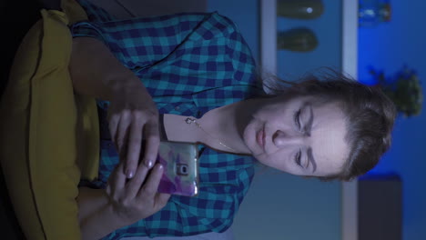 Vertical-video-of-The-woman-texting-on-the-phone-at-night-is-unhappy-and-sad.